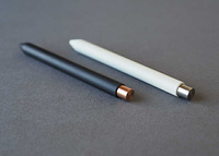 Two Mark One pens, side by side. One black, one white.