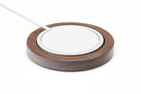 A wooden puck holding an iPhone MagSafe charger in its center.